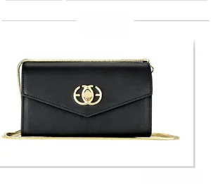 Close-up of black envelope crossbody bag with gold chain and circular metal lock