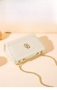 Détail du sac crème avec logo anneaux dorés entrelacés et bandoulière en chaîne