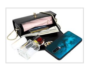 Detail view of mini black leather crossbody bag showing internal capacity for phone and cards