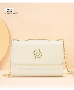 Détail du sac bandoulière blanc sable avec chaîne dorée et logo métallique entrelacé