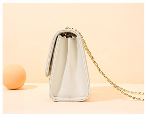 Détail du sac bandoulière blanc cassé avec chaîne dorée et vue latérale structurée