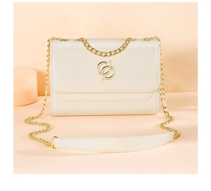 Détail d'un sac à bandoulière blanc crème avec logo doré et chaîne en métal doré