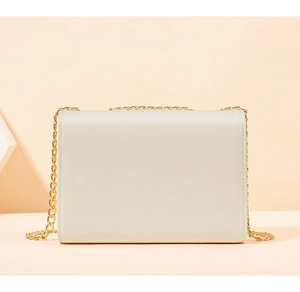 Détail du dos en similicuir lisse et de la chaîne dorée de ce sac à main beige élégant