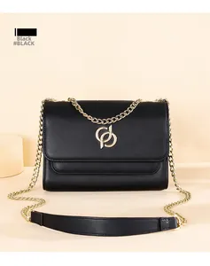 Détail du sac à bandoulière en cuir noir avec logo doré et bandoulière chaîne