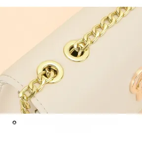 Détail de la chaîne dorée et du logo sur le sac à bandoulière en cuir beige chic