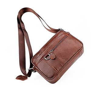 Close-up of brown litchi grain leather crossbody bag with metal ring and zip detail
