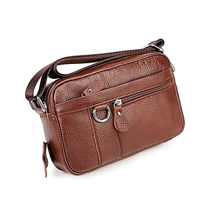 Detail view of genuine leather messenger bag with pebble grain texture and silver zippers