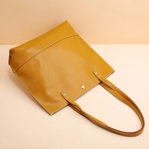 Sac fourre-tout minimaliste en cuir jaune gingembre avec texture grainée et boucle dorée