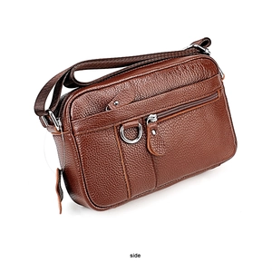 Side view of brown pebbled leather crossbody bag with metal zippers and woven strap