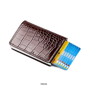Detail view of the brown crocodile pattern wallet showing the card ejection mechanism