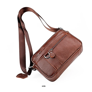 Detail of brown litchi pattern leather crossbody bag with zipper and metal D-ring