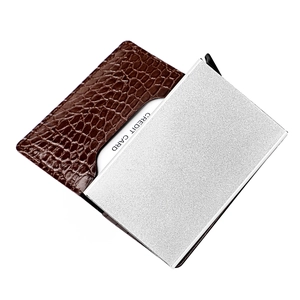 Close-up of brown crocodile texture leather and silver aluminum pop-up card holder