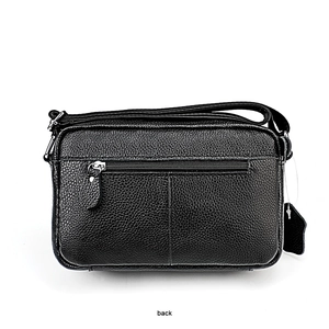 Detailed back view of a black pebbled leather crossbody bag with zipper pocket and strap