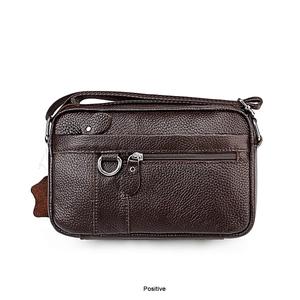 Detail of dark brown lychee leather texture with zipper pocket and metal D-ring on bag