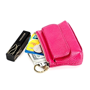 Rose red leather coin purse with zipper and key ring shown holding coins and lipstick