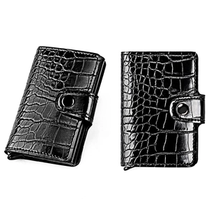 Detail of black crocodile pattern wallet with secure snap fastener and metal card holder