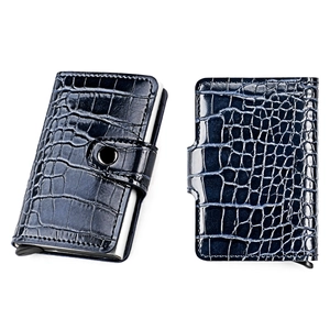 Macro detail of deep blue crocodile textured slim wallet with automatic pop-up card ejector