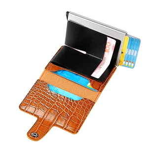 Detail of pop-up metal card slot and brown crocodile leather wallet with snap closure