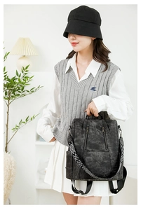 Detail of vintage black backpack with decorative geometric strap and metal zippers