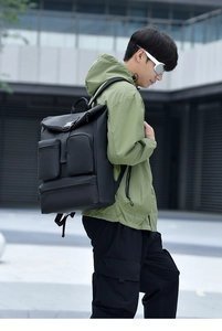 Waterproof black business commute backpack shown on a model in an urban city square