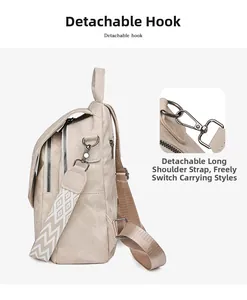 Detail of detachable metal hooks and geometric patterned shoulder strap on beige backpack