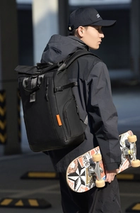 Détail du sac à dos extérieur noir à fermeture roll-top avec sangles orange