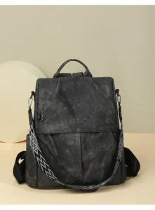 Dettaglio dello zaino grigio testurizzato con tracolla decorativa in tessuto geometrico