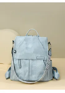 Dettaglio dello zaino grigio-blu che mostra la texture in pelle lavata e la tracolla a motivi
