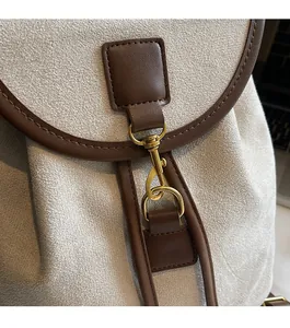 Close-up of durable golden metal hook and leather strap on matte textured backpack
