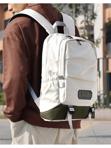 Outdoor shot of an off-white travel backpack with olive green base and side pockets