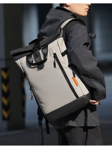 Détail d'un sac à dos roll-top extensible en tissu déperlant avec des zips orange vifs