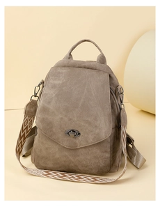 Detail of taupe backpack featuring wide geometric jacquard strap and twist lock