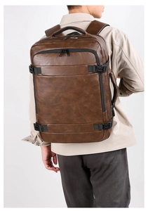 Detail of premium brown faux leather texture and metallic zippers on men's backpack