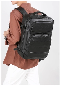Side view of large black leather business backpack with multi-layer zipper compartments