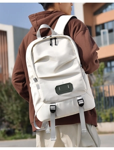 Detail of off-white travel backpack with matte waterproof fabric and front zip pocket
