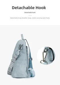 Detail view of the detachable gray wavy strap and metal hook on the blue canvas backpack