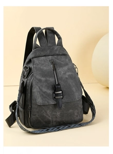Detail of vintage charcoal backpack with patterned shoulder strap and metal hardware