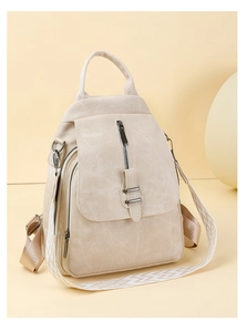 Detail view of the cream leather backpack featuring a stylish patterned shoulder strap and hardware