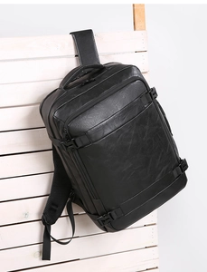 Detail of black PU leather backpack showing fine lychee texture and side buckle fasteners