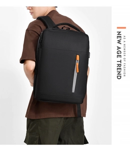 Detail of black commuter backpack with orange zipper pull and reflective safety strip