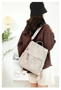 Dettaglio dello zaino beige con tracolla in tessuto a motivi geometrici vintage
