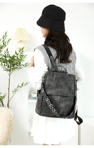 Dettaglio dello zaino grigio leggero con tracolla intrecciata a motivi geometrici chic