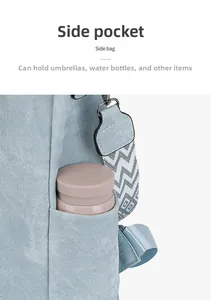 Detail of light blue canvas backpack side pocket with a pink water bottle and woven strap