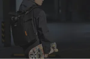 Détail du sac à dos noir roll-top montrant la boucle extensible et la texture nylon