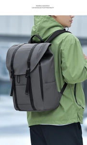 Close-up of stylish grey backpack with flap lid and buckle straps on a male model