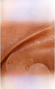 Detail of waterproof brown PU leather backpack showing scratch-resistant fabric texture