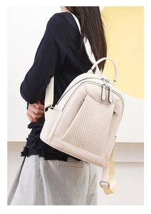 Detail of cream leather backpack featuring V-shaped quilting and silver metal buckles