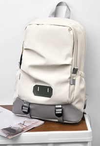 Detail of travel backpack with 'Believe in yourself' patch and adjustable silver buckles