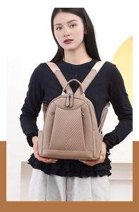 Close-up of khaki faux leather backpack with V-shape quilting and wide woven straps