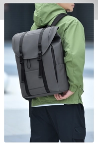 Outdoor model wearing a large dark grey travel backpack with flap cover and buckle closure
